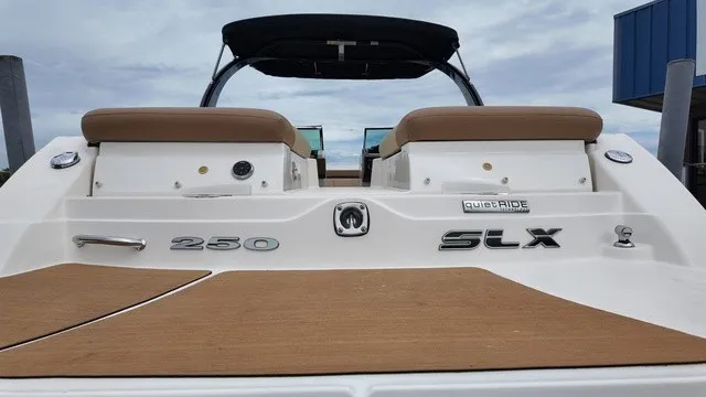 Slide: The Image of The image shows the stern of a 2015 Sea Ray SLX 250 boat with brown seats. - 12