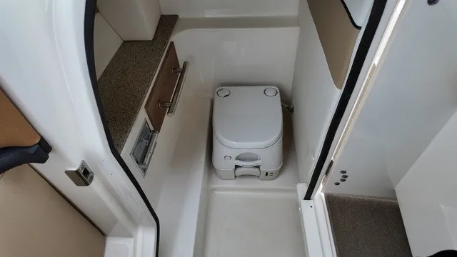 Slide: The Image of The image shows a compact boat toilet in a 2015 Sea Ray SLX 250. - 20
