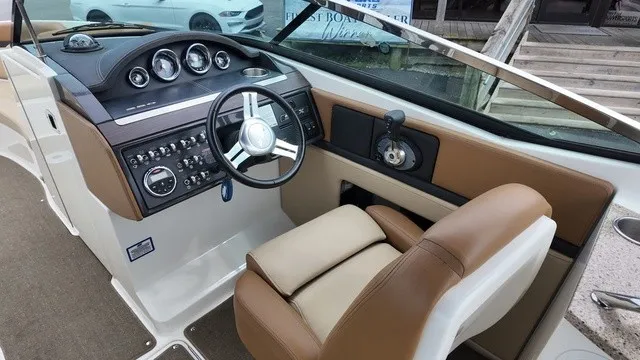Slide: The Image of The image shows the cockpit of a 2015 Sea Ray SLX 250 with a sleek steering wheel and dashboard. - 22