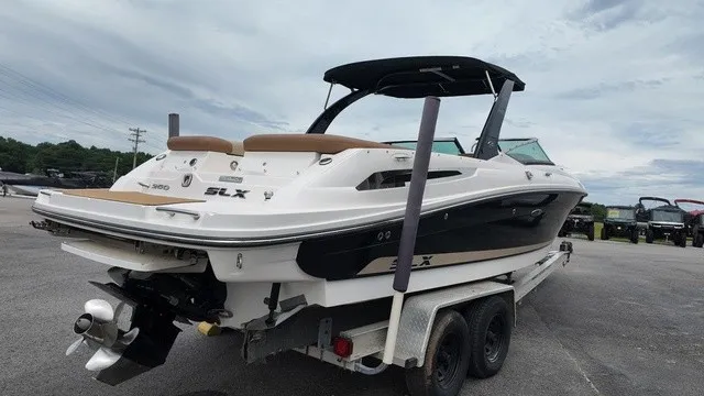 Slide: The Image of A 2015 Sea Ray SLX 250 boat on a trailer, featuring a black hull and brown seating. - 5