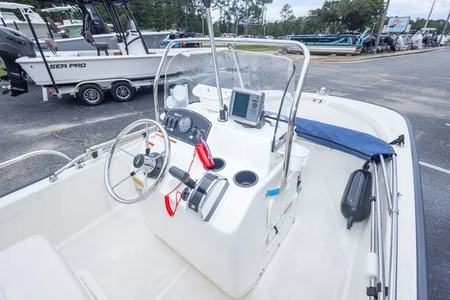 Slide: The Image of The image shows the cockpit of a 2012 Boston Whaler 150 Montawk with steering and instruments. - 17