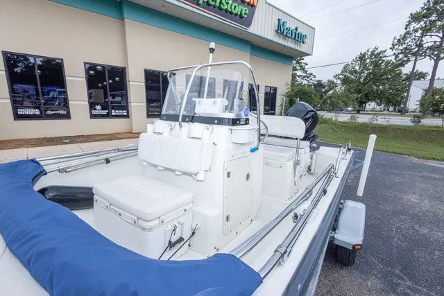 Slide: The Image of A 2012 Boston Whaler 150 Montawk is parked. It features a central console and white seating. - 13