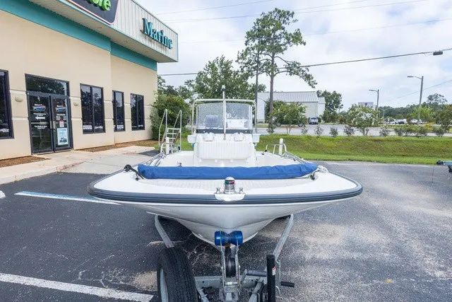 Slide: The Image of A 2012 Boston Whaler 150 Montawk on a trailer in front of a building. - 9