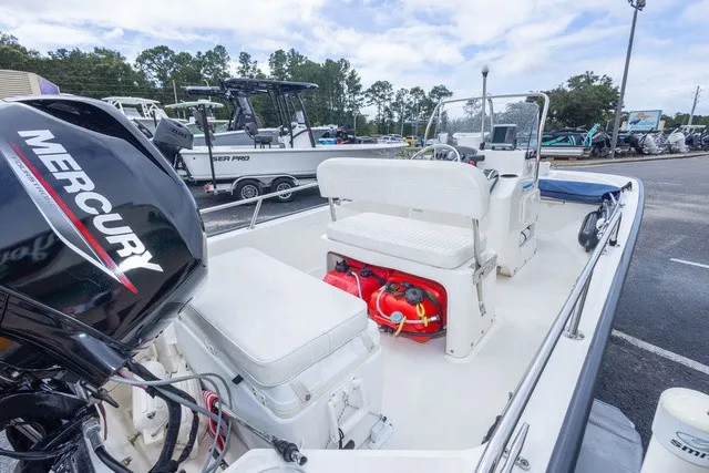 Slide: The Image of A 2012 Boston Whaler 150 Montawk with a Mercury outboard motor, white seats, and red canister. - 11