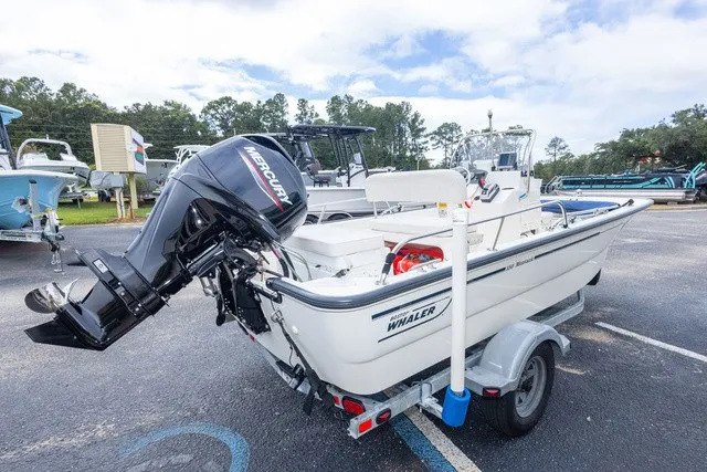 Slide: The Image of A 2012 Boston Whaler 150 Montawk on a trailer, featuring a Mercury outboard motor. - 3