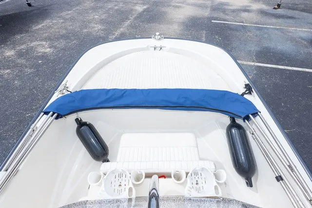Slide: The Image of The image shows the bow of a 2012 Boston Whaler 150 Montawk with a blue cover. - 19