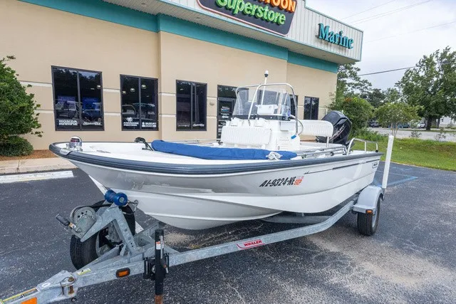 Slide: The Image of A 2012 Boston Whaler 150 Montawk on a trailer in front of a store. - 8