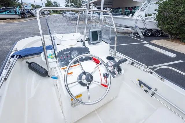 Slide: The Image of The image shows the cockpit of a 2012 Boston Whaler 150 Montawk. It features a steering wheel, instruments, and a windshield. - 15
