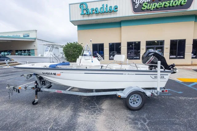 Slide: The Image of A 2012 Boston Whaler 150 Montawk on a trailer in front of a store. - 7