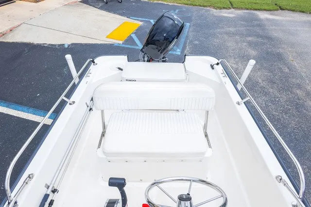 Slide: The Image of The image shows the cockpit of a 2012 Boston Whaler 150 Montawk with white seating and steering. - 20