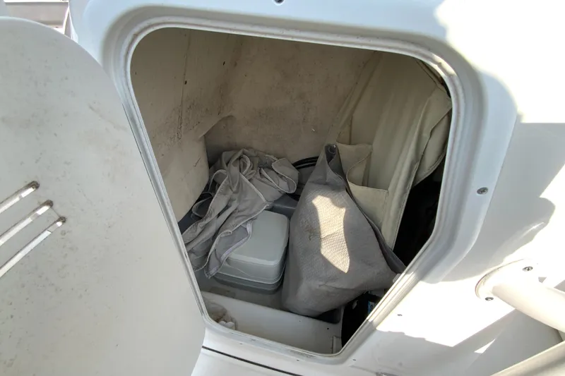 Slide: The Image of Storage compartment inside a 2015 Tidewater 230 CC Adventure boat, containing various items. - 26
