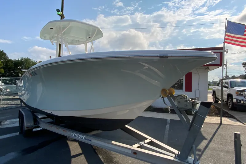 Slide: The Image of 2015 Tidewater 230 CC Adventure boat on trailer, parked outdoors under a blue sky. - 3
