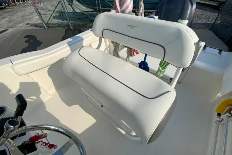 Slide: The Image of 2015 Tidewater 230 CC Adventure boat interior with white seating and steering wheel. - 14