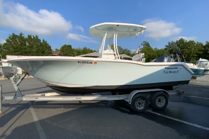 Slide: The Image of 2015 Tidewater 230 CC Adventure boat on trailer, parked outdoors under blue sky. - 6