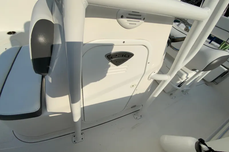 Slide: The Image of 2015 Tidewater 230 CC Adventure boat interior, featuring seating and storage compartment. - 25