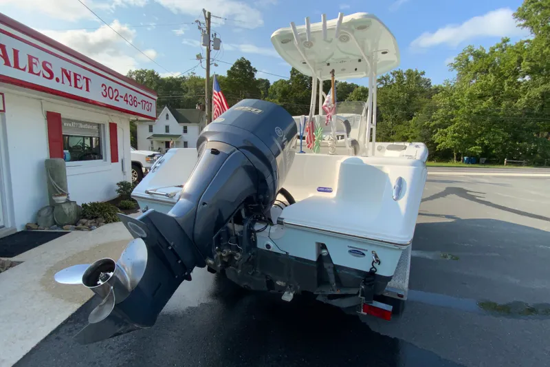 Slide: The Image of 2015 Tidewater 230 CC Adventure boat with powerful outboard motor, parked near a sales office. - 10