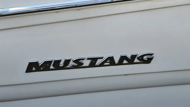Slide: The Image of Close-up of the Mustang logo on a white boat hull. - 25