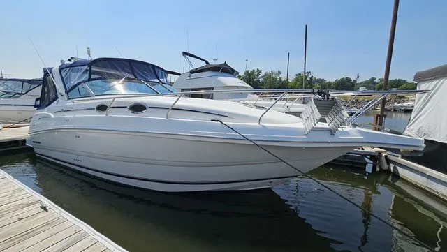Slide: The Image of A white 2001 Mustang 3200 Sport Cruiser docked in the water. - 3