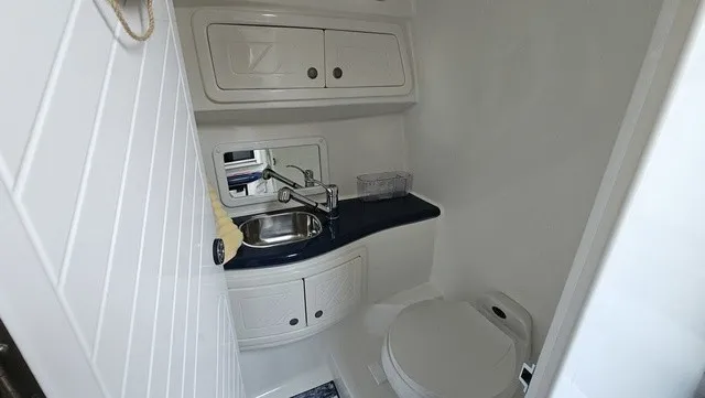 Slide: The Image of The image shows a clean, modern boat bathroom with a sink and toilet. - 22