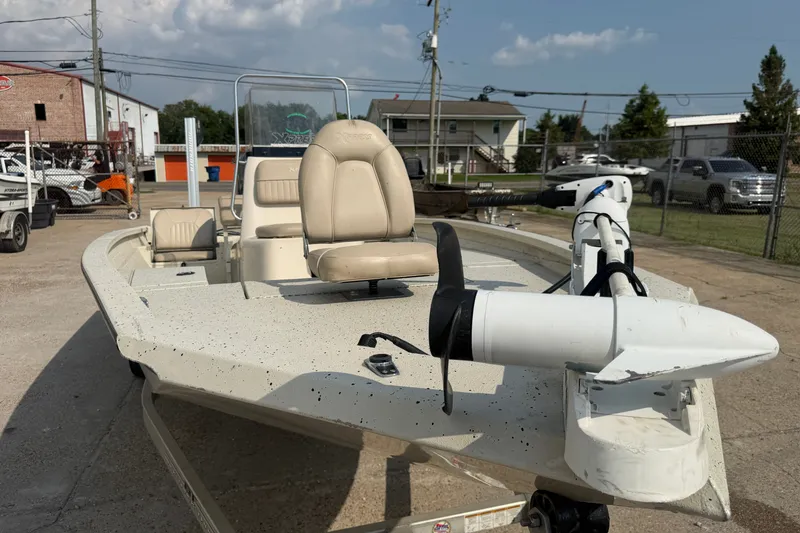 Slide: The Image of 2013 Xpress H20B Bay boat with beige seating and trolling motor, parked outdoors. - 9