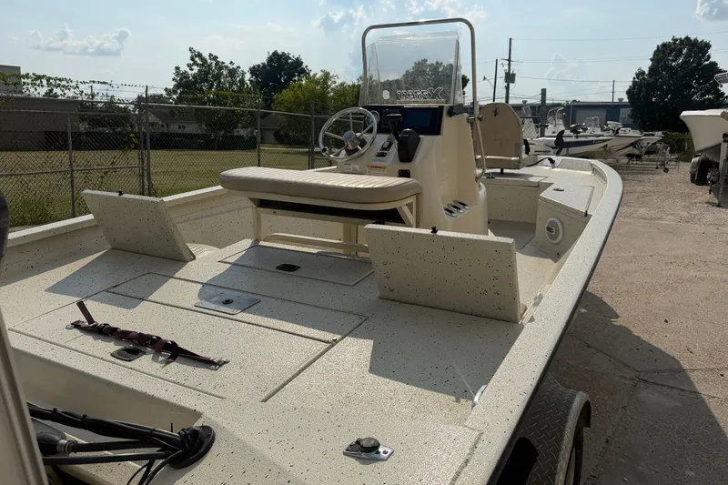 Slide: The Image of 2013 Xpress H20B Bay boat with center console and seating, parked outdoors. - 13