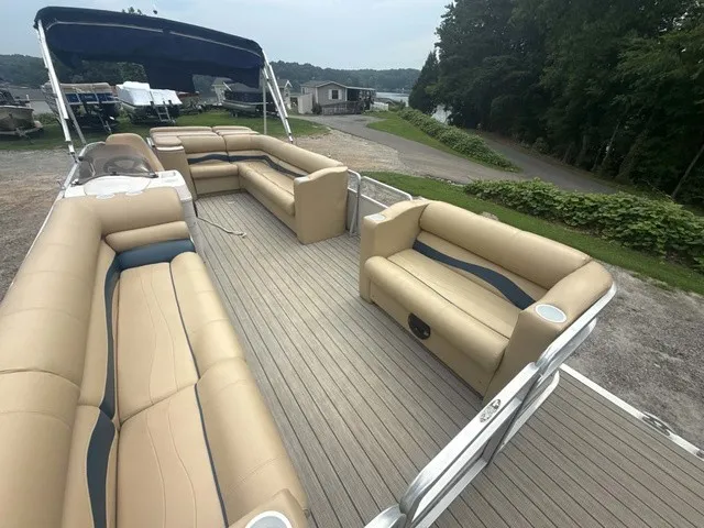 Slide: The Image of A 2002 Harris Sunliner 220 pontoon boat with beige seating and blue accents, on a trailer. - 4