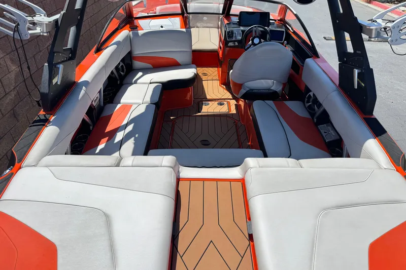 Slide: The Image of 2018 Malibu Wakesetter 22 MXZ interior with orange and white seating, sleek design. - 9