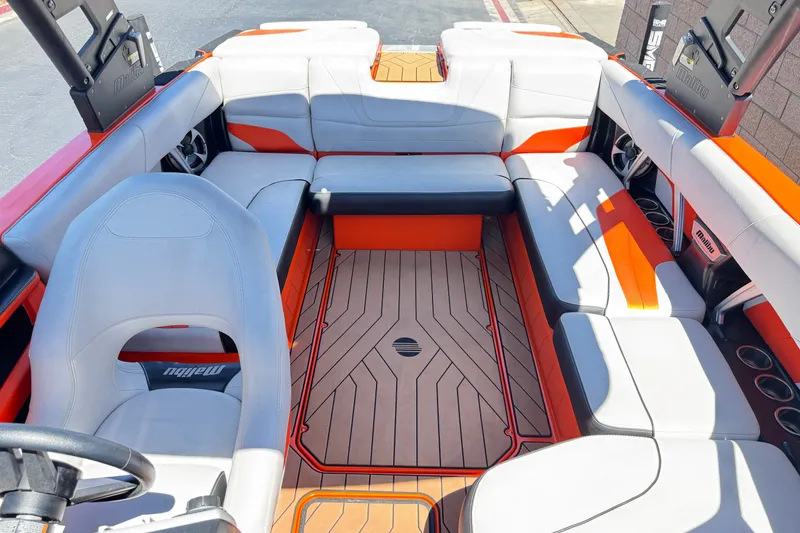 Slide: The Image of 2018 Malibu Wakesetter 22 MXZ interior with orange and white seating, showcasing spacious design. - 19