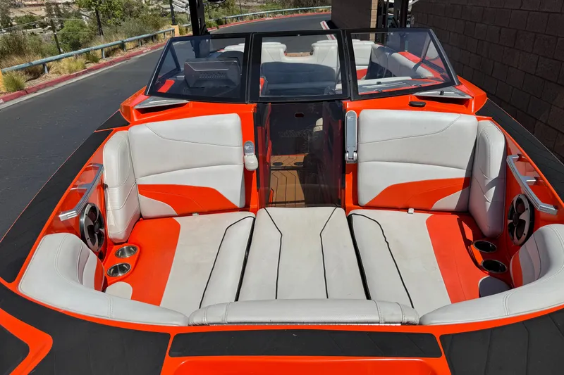 Slide: The Image of 2018 Malibu Wakesetter 22 MXZ boat interior with orange and white seating. - 12