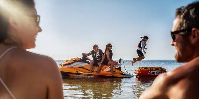 Slide: The Image of A 2017 Sea-Doo GTI SE 130 in the water with people enjoying themselves. - 6