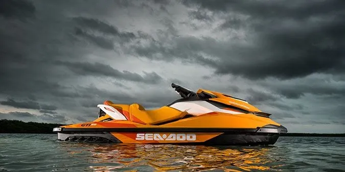 The Image of A yellow 2017 Sea-Doo GTI SE 130 jet ski floats on calm water under a cloudy sky. - 4