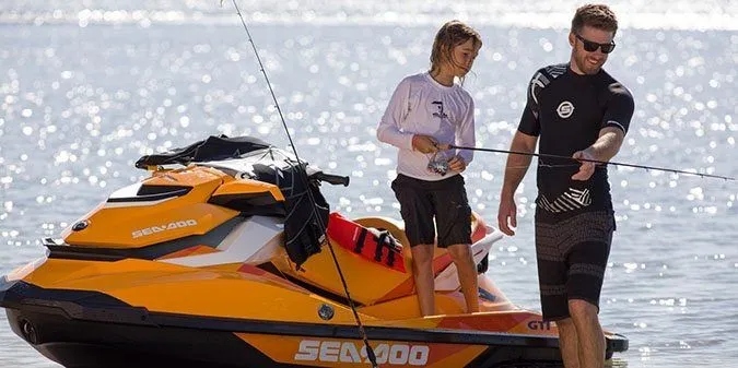 Slide: The Image of An orange 2017 Sea-Doo GTI SE 130 jet ski on the water with two people. - 2