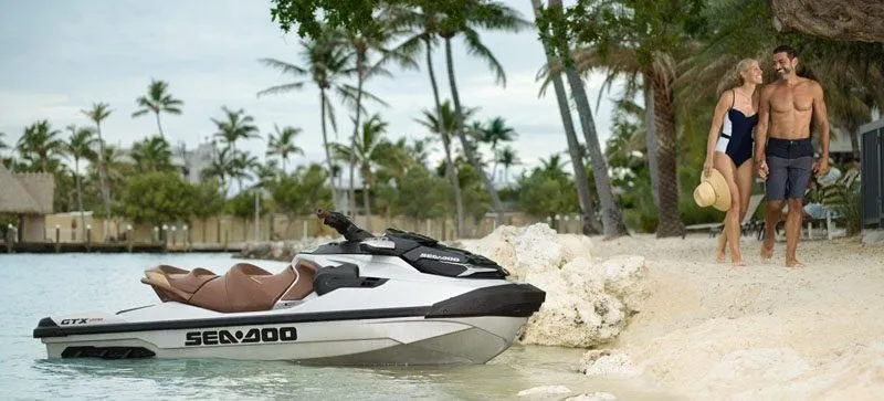 Slide: The Image of A 2019 Sea-Doo GTX Limited 300 is on the beach. A couple walks along the water. - 7