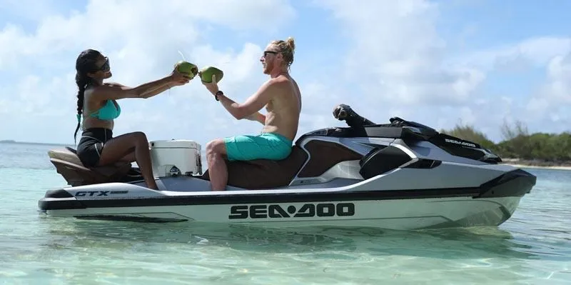 Slide: The Image of Two people sit on a Sea-Doo GTX Limited 300 jet ski, toasting with coconuts. - 6
