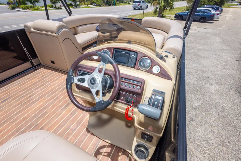 Slide: The Image of Steering console of a 2017 South Bay 523SL pontoon boat with beige seating. - 35