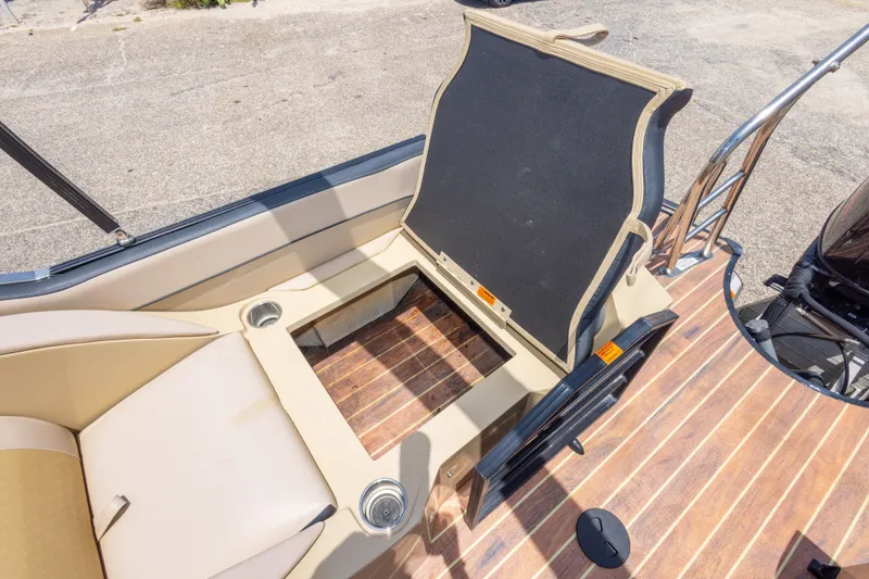 Slide: The Image of 2017 South Bay 523SL boat interior with open storage compartment and cup holders. - 21