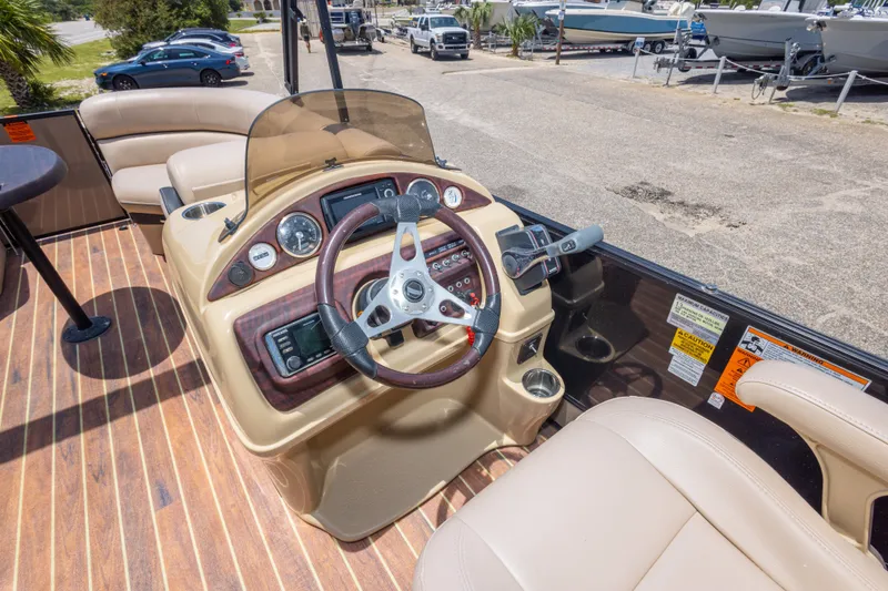 Slide: The Image of 2017 South Bay 523SL boat dashboard with steering wheel and controls, featuring beige seating. - 34