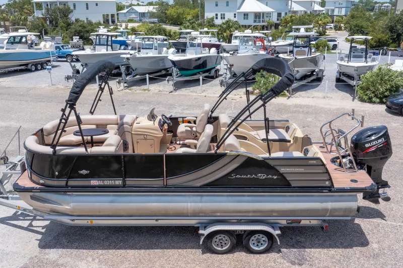 Slide: The Image of 2017 South Bay 523SL pontoon boat with Suzuki outboard motor, parked in a marina. - 4