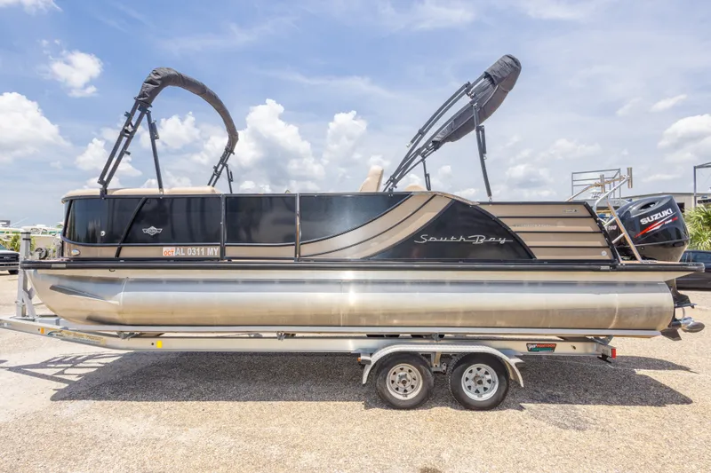 Slide: The Image of 2017 South Bay 523SL pontoon boat on trailer under a clear blue sky. - 10