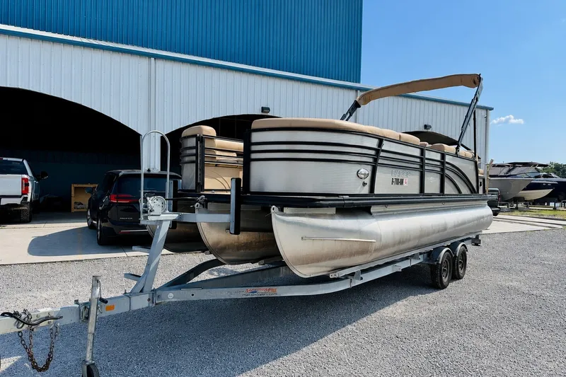 Slide: The Image of 2019 Harris Sunliner 230 pontoon boat on trailer outside storage facility. - 1