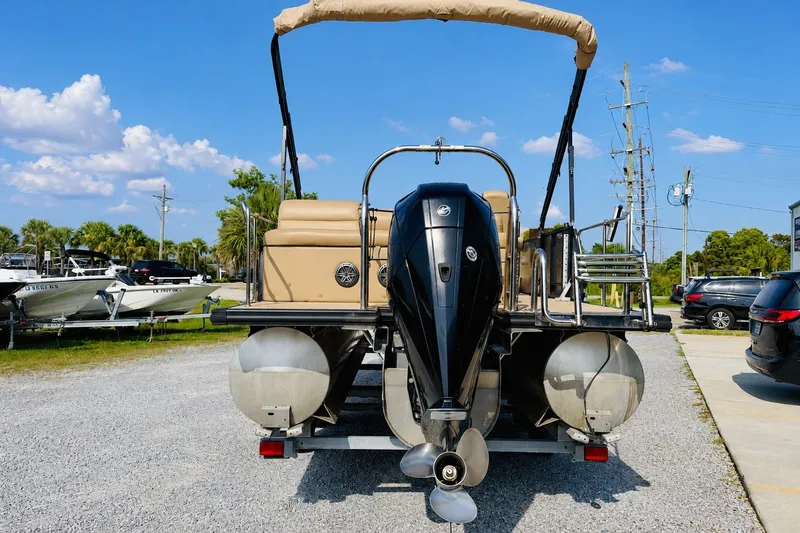Slide: The Image of 2019 Harris Sunliner 230 pontoon boat with outboard motor, parked on gravel lot. - 4