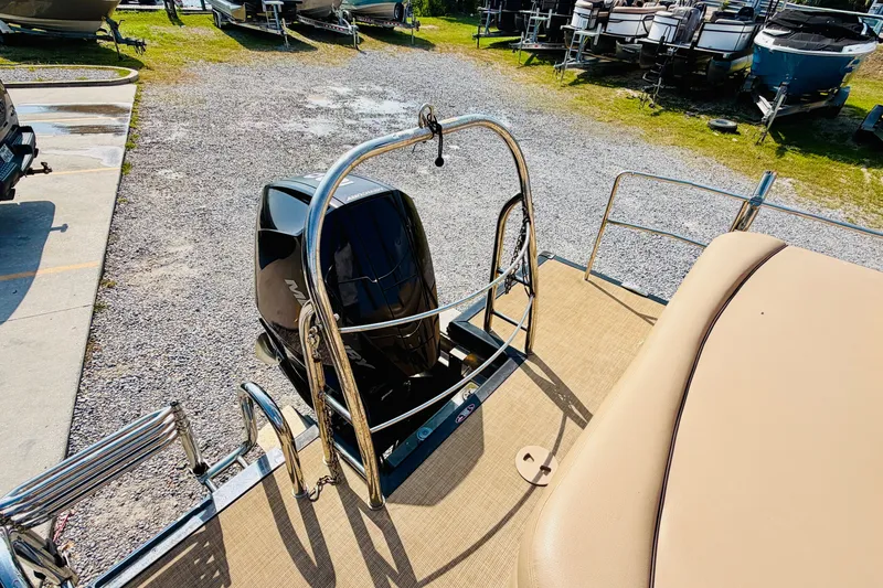 Slide: The Image of 2019 Harris Sunliner 230 boat with Mercury outboard motor, parked on gravel lot. - 20