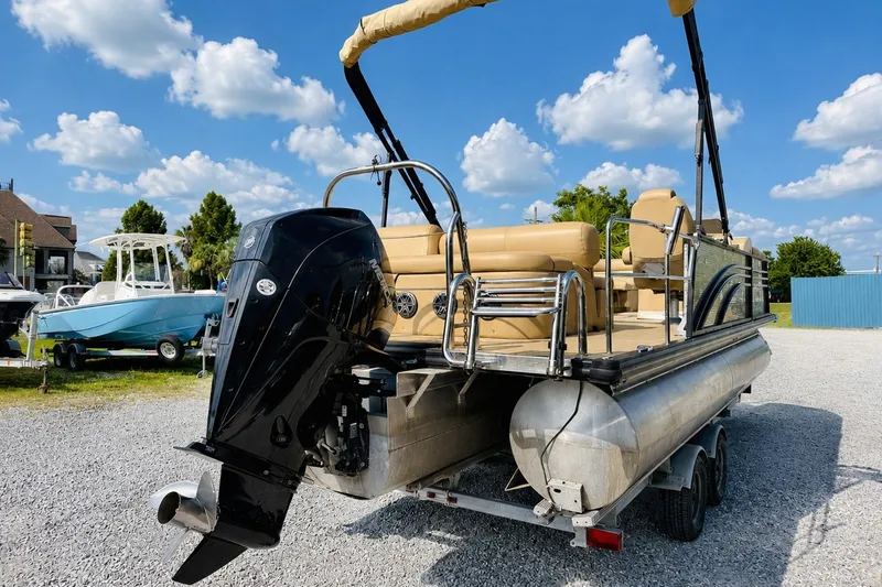 Slide: The Image of 2019 Harris Sunliner 230 pontoon boat with outboard motor on a trailer under a blue sky. - 5