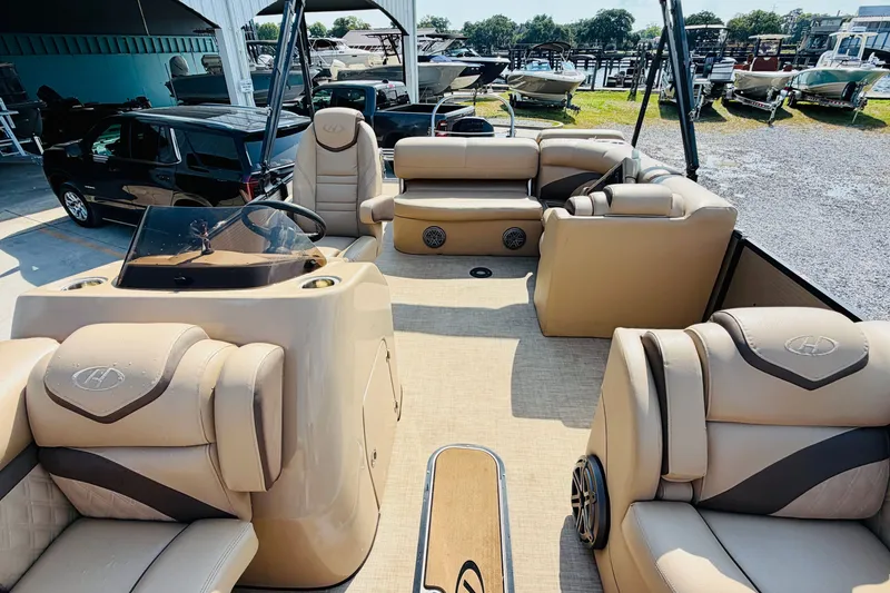Slide: The Image of 2019 Harris Sunliner 230 pontoon boat interior with beige seating and steering console. - 12