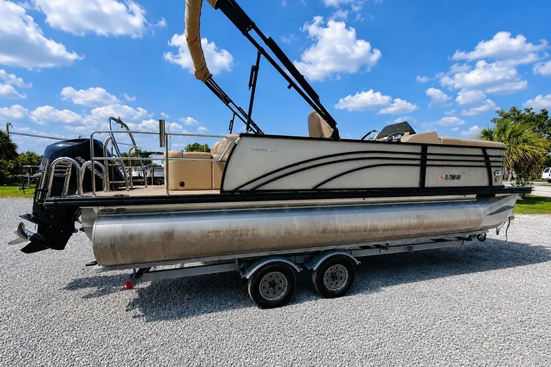 Slide: The Image of 2019 Harris Sunliner 230 pontoon boat on trailer under a blue sky. - 3