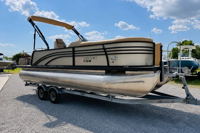 Slide: The Image of 2019 Harris Sunliner 230 pontoon boat on trailer under a clear blue sky. - 2