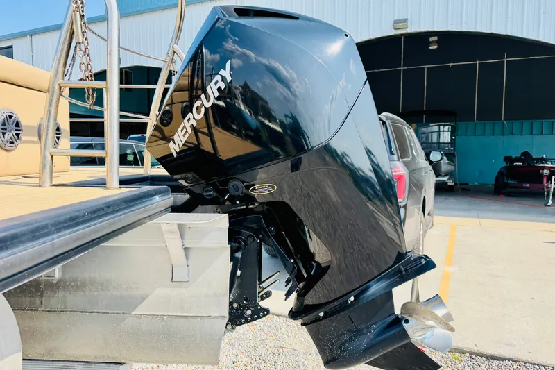 Slide: The Image of 2019 Harris Sunliner 230 with Mercury outboard motor, parked near a building. - 8