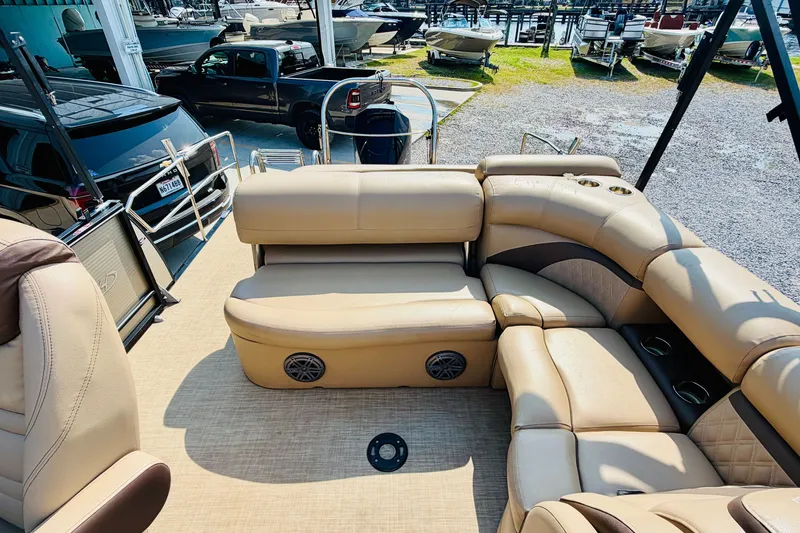 Slide: The Image of 2019 Harris Sunliner 230 pontoon boat interior with beige seating and cup holders. - 16