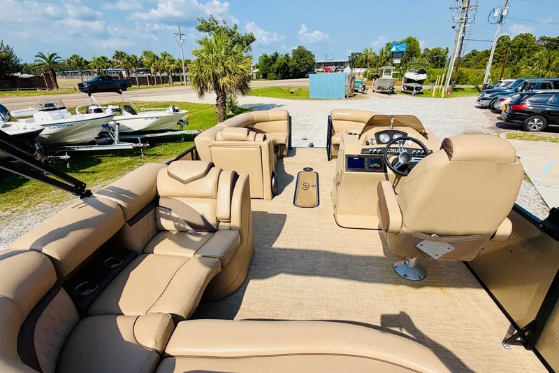 Slide: The Image of 2019 Harris Sunliner 230 pontoon boat with beige seating and modern dashboard. - 22