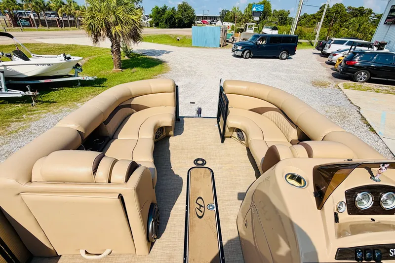 Slide: The Image of 2019 Harris Sunliner 230 pontoon boat with beige seating and dashboard, parked outdoors. - 13